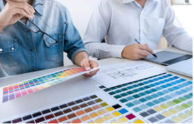Deux hommes à Bromont regardent des palettes de couleurs. Il y a un plan d'architecte sur la table.